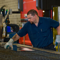 A Matot worker inspects a sheet of metal to be used in a dumbwaiter.