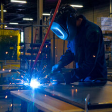 A Matot worker welds a metal component to be used in a dumbwaiter.